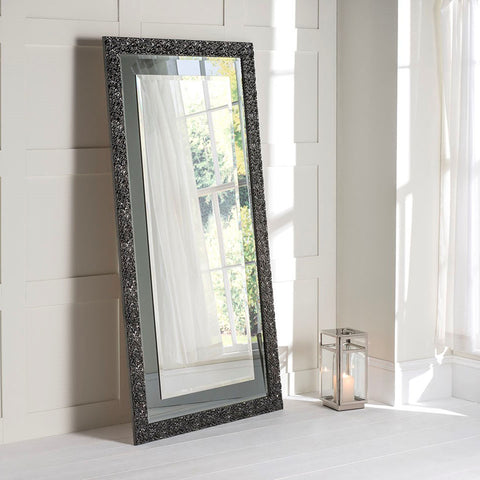 grey frame leaner mirror leaning up against the wall